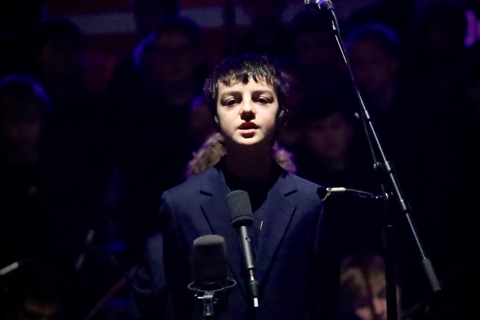 Ung solist synger i mikrofon på konsert